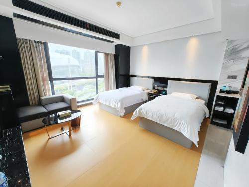 a bedroom with two beds and a living room at Zhangjiajie Merlot Crystal Hotel in Zhangjiajie