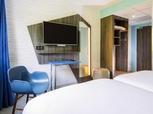a hotel room with a bed and a tv at Ibis Styles Sallanches Pays du Mont-Blanc in Sallanches