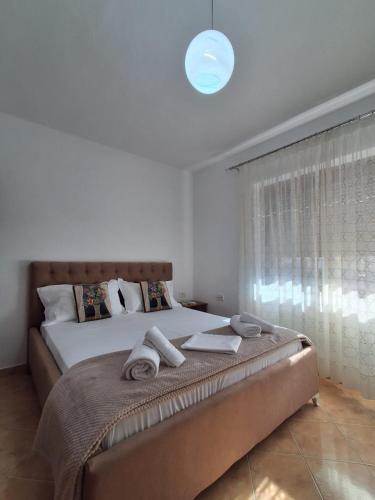 a bedroom with a large bed with towels on it at Vangert Apartment in Berat
