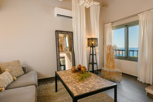 a living room with a couch and a table and a mirror at Braunis Horio Villas in Asos