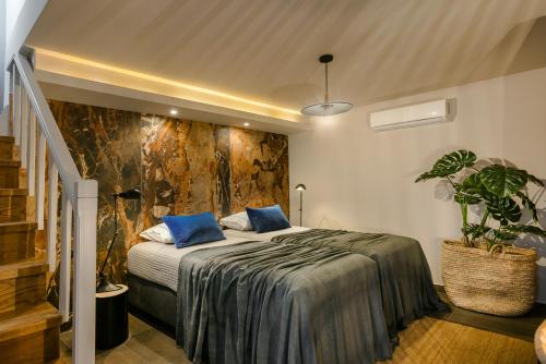 a bedroom with a large bed with blue pillows at Braunis Horio Villas in Asos