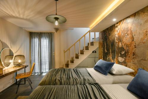 a bedroom with a large bed and a staircase at Braunis Horio Villas in Asos