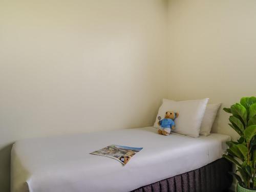 a teddy bear sitting on top of a bed at Mercure Albury in Albury