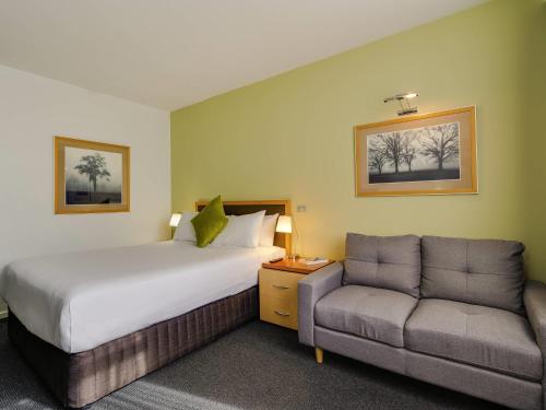 a hotel room with a bed and a couch at Mercure Albury in Albury