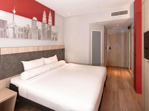 a bedroom with a large white bed in it at ibis Kuala Lumpur City Centre in Kuala Lumpur