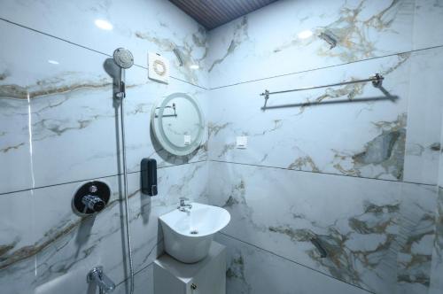 a white bathroom with a sink and a mirror at Nirvana-Vadanappally Beach Villa in Irimbranallūr