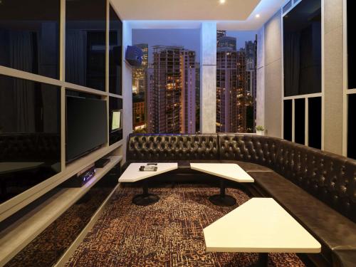 a bar with a couch and a view of the city at ibis Kuala Lumpur City Centre in Kuala Lumpur