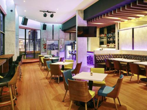 a restaurant with tables and chairs and a bar at ibis Kuala Lumpur City Centre in Kuala Lumpur