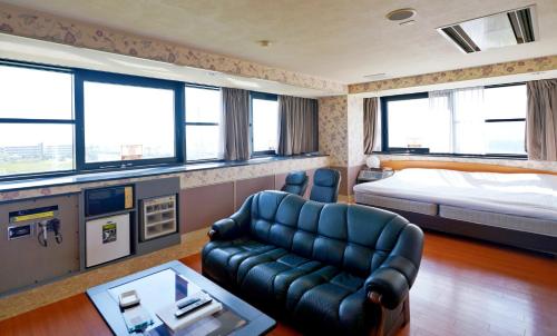 a living room with a couch and a bed at ホテル韮崎インター in Nirasaki