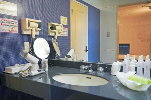 a bathroom counter with a sink and a mirror at ホテル韮崎インター in Nirasaki