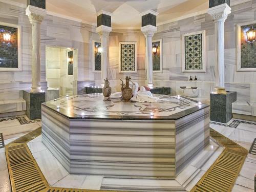 a large lobby with a fountain in the middle of a building at Rixos President Hotel Astana in Astana