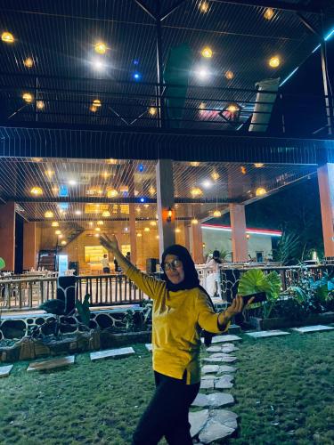a woman is standing with her arms in the air at Lalinggo Bungalow in Tetebatu