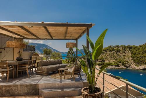 a patio with a table and chairs and a view of the water at Braunis Horio Villas in Asos