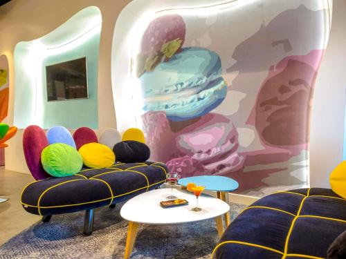 a room with chairs and a wall with a mural at ibis Styles Fréjus St Raphael in Fréjus
