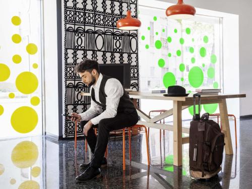 a man sitting at a table in a room at Ibis Styles Brindisi in Brindisi