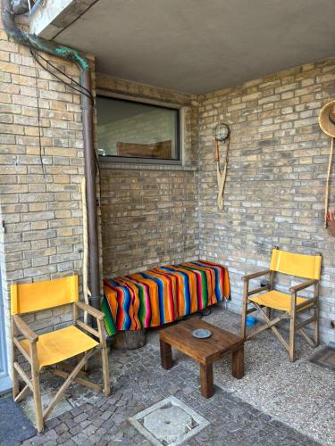 a room with a bed and two chairs and a window at Casa Momi b&b and in Novilara