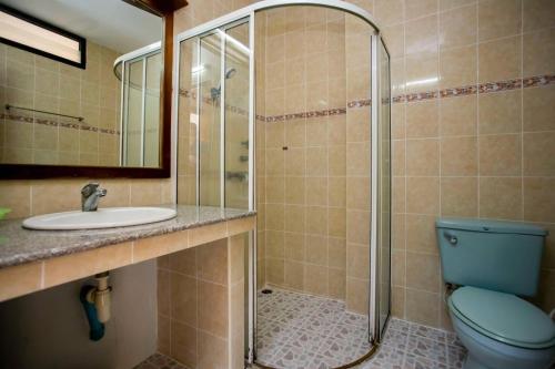 a bathroom with a toilet and a sink and a shower at Sinsiam Resort in Ban Ang