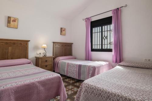 una habitación con dos camas y una ventana en Casa Carmelo Conil 2, en Conil de la Frontera