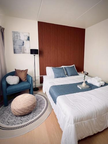a bedroom with a large bed and a chair at Happy House T8 in Thung Si Kan