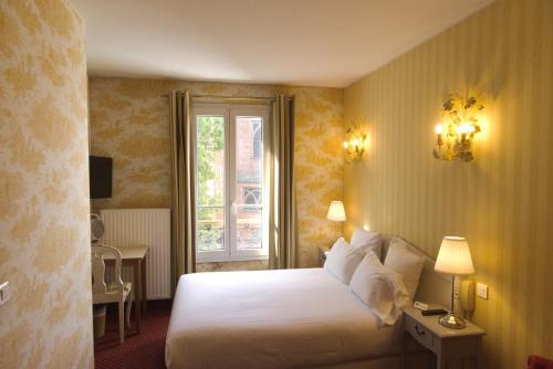 a hotel room with a bed and a window at Hôtel Regyn's Montmartre in Paris