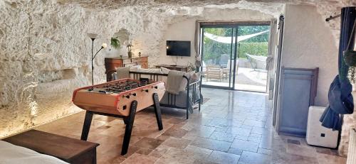 a living room with a ping pong table in it at Troglo la Roche Tourangelle et vélos in Civray-de-Touraine