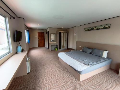 Un dormitorio con una cama grande y una ventana. en Peter's house2 Five minutes to the beach, en Pattaya South
