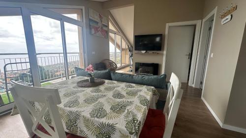 a dining room table with a view of a balcony at Casa Malee in Calheta