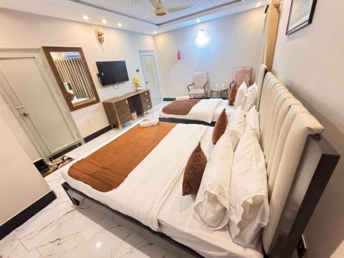 a bedroom with a large bed in a room at Hotel BlueSky Clifton 2 in Dargai