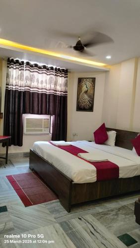 a bedroom with a large bed in front of a window at New Shanti Hotel in Prayagraj