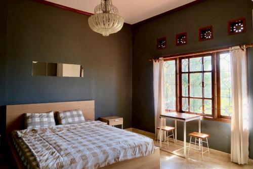 a bedroom with a bed and a window and a desk at Aiwan Hostel & Luggage storage in Sanur