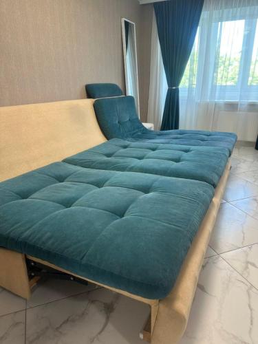 a large bed with a large blue blanket on it at Одеська 129 in Golta