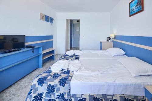 a bedroom with two beds and a tv at Palace Hotel in Sunny Beach