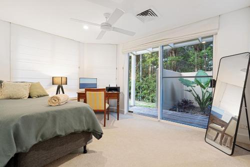 una camera da letto con un letto, una scrivania e una finestra di Villa San Michele a Coolum Beach