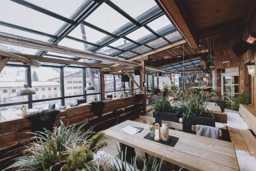 a restaurant with tables and chairs and a glass ceiling at THOMSN Central Hotel & Appartements in Saalbach Hinterglemm