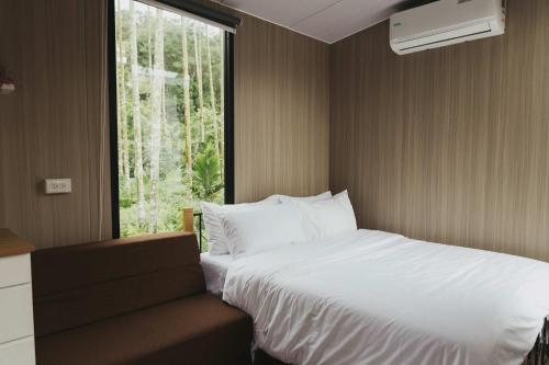 a bedroom with a white bed and a window at California Good Day Campground X by Tiny Away in T'ai-ping