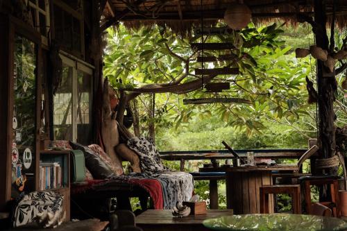 a woman sitting in a chair in a room with a window at Seree Bungalows & Chill Bar in Ko Chang