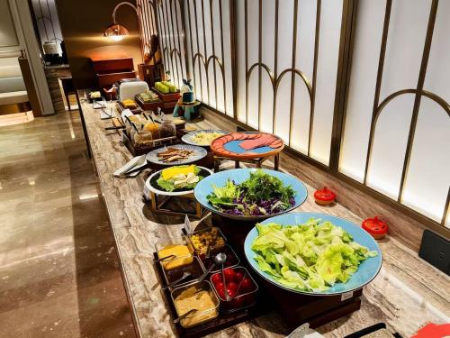 上海上海陆家嘴美居酒店的餐桌上的自助餐,包括几盘食物
