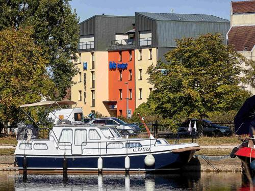 a boat docked in the water in front of a building at ibis budget Auxerre Centre in Auxerre