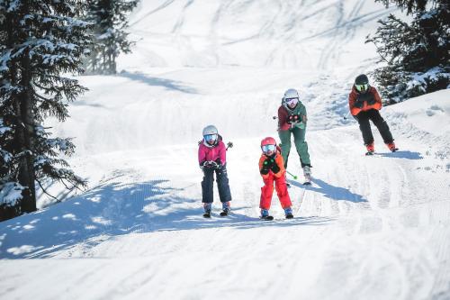 a group of people skiing down a snow covered slope at THOMSN Central Hotel & Appartements in Saalbach Hinterglemm