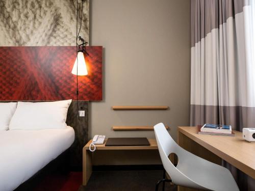 a hotel room with a bed and a desk and a bed and a desk at ibis Vilnius Centre in Vilnius