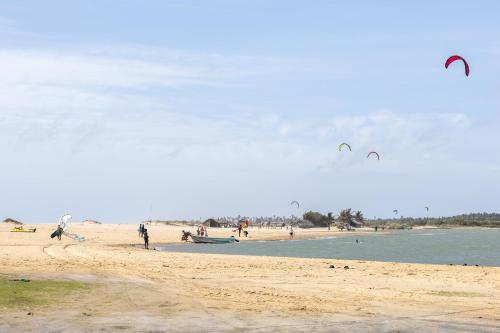 a group of people on a beach flying kites at Barramundi in Puttalam