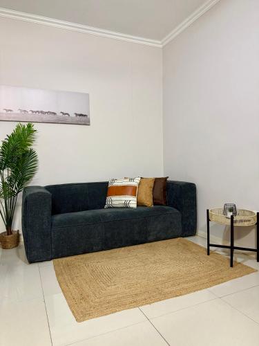 a living room with a blue couch and a table at uMhlanga Condo - Location, Location, Location in Durban