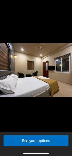 a bedroom with a large white bed with two windows at Rocks beach house in Kannur