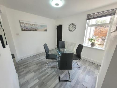 a dining room with a glass table and chairs at Ipswich 2-Bed Home Near Marina & Town - Free Parking in Ipswich