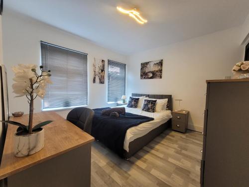 a bedroom with a bed and a vase of flowers at Ipswich 2-Bed Home Near Marina & Town - Free Parking in Ipswich