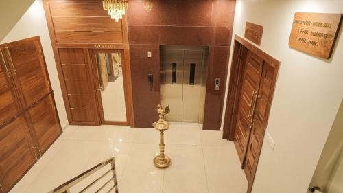 a hallway with wooden doors and a white tile floor at Ganesh Residency 