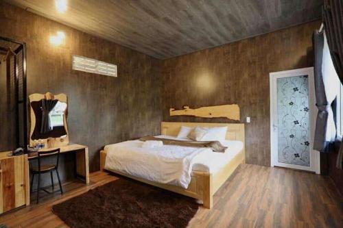 a bedroom with a bed and a desk and a mirror at HomeStay Thiên Phúc in Ấp Ðinh An (1)