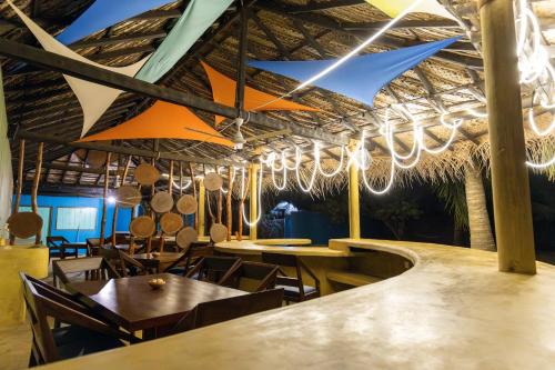 a restaurant with tables and chairs and chandeliers at Barramundi in Puttalam
