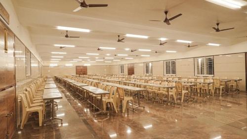 a large room with long tables and chairs at Ganesh Residency 