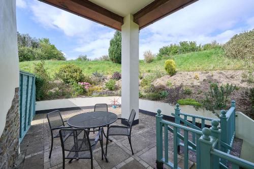 a patio with a table and chairs on a porch at Host & Stay - Coombe Cottage in Knowstone